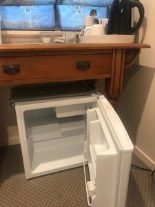 an open refrigerator under a table with a sink at TAURANGA, Bay of Plenty in Tauranga