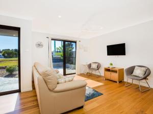 a living room with two chairs and a tv at Villa Zelma I Pet Friendly I 4 Min Walk to Beach in Culburra Beach