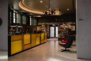 a lobby with a yellow counter and a red chair at The Old Clare Hotel, Independent Collection by EVT in Sydney