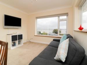 a living room with a couch and a flat screen tv at Tideways in Exeter