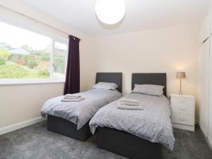two beds in a bedroom with a window at Tideways in Exeter