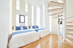 two beds in a white room with a spiral staircase at プール&サウナヴィラ美ら海本部 in Motobu +53 photos