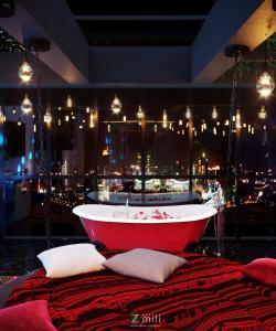 una vasca da bagno rossa seduta sopra un letto di Zen Hotel Hạ Long a Ha Long