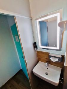a bathroom with a sink and a mirror at CREO Hotel Dessau in Dessau