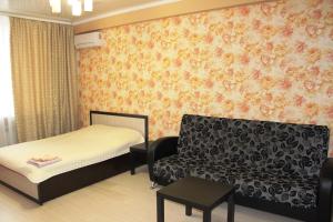 a small room with a bed and a couch at Апартаменты на пр Победы OrenRoom in Orenburg