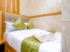 1 dormitorio con 1 cama con sábanas y almohadas blancas en Hotel Al Fatah, en Bombay