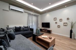 a living room with a couch and a tv at Aria apartment in the heart of Corfu city in Ágios Rókkos