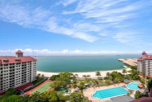 uma vista para a praia a partir da varanda de um resort em Glory Beach Resort em Porto Dickson
