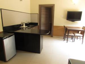 a kitchen with a black counter top and a table at Sandalwood Hotel & Suites in Panaji