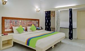 a bedroom with a large white bed with colorful pillows at Hotel Meera Udaipur in Udaipur