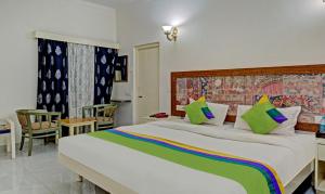 a bedroom with a large bed with green pillows at Hotel Meera Udaipur in Udaipur