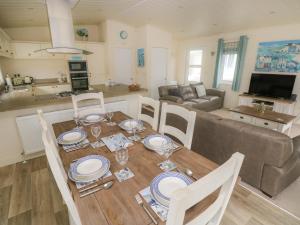 a dining room and living room with a table and chairs at Cwtch Lodge 42 in Narberth