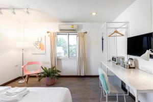 a room with a bed and a desk with chairs at 4 bedrooms Family at Chiang Mai Old City in Chiang Mai