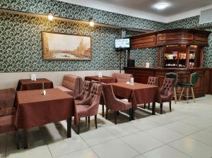 a dining room with tables and chairs and a tv at Korona Hotel in Yoshkar-Ola