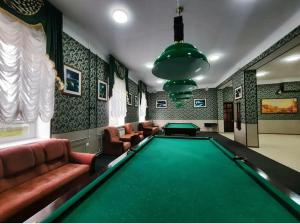 a billiard room with a pool table and couches at Korona Hotel in Yoshkar-Ola