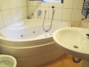 a bathroom with a tub and a sink and a toilet at Zum Gebimmel in Waldesch