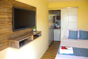 uma sala de estar com uma televisão de ecrã plano na parede em Flat Vista Mar Noronha em Fernando de Noronha