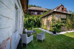 a backyard with chairs and a table and a building at Mała Kuźnia in Lanckorona