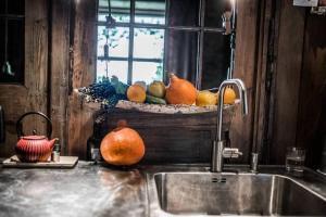 a kitchen sink with a bowl of fruit on a window sill at Mała Kuźnia in Lanckorona