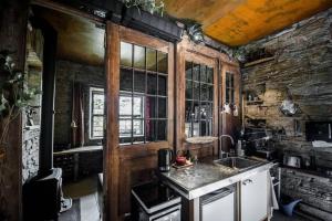 cocina con fregadero y pared de piedra en Mała Kuźnia, en Lanckorona