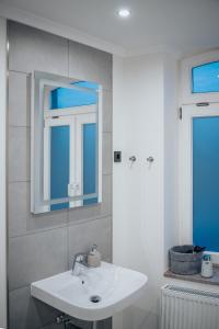 a bathroom with a white sink and a mirror at Hotel & Restaurant Christian IV in Glückstadt