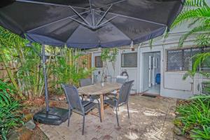a table and chairs with an umbrella on a patio at A cozy Palm Cove unit 3 with a private garden in Palm Cove