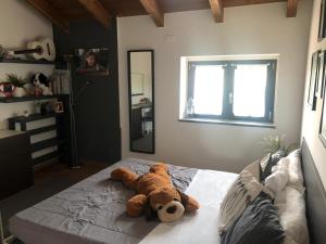 a teddy bear laying on a bed in a bedroom at Corte Di Frara in Parma