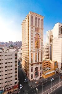 un edificio alto en medio de una ciudad en Dhiafat Al Raja Hotel, en La Meca