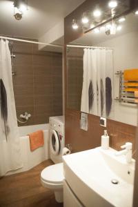ein Badezimmer mit einem Waschbecken, einem WC und einem Spiegel in der Unterkunft Apartment FeLi House in Kiew