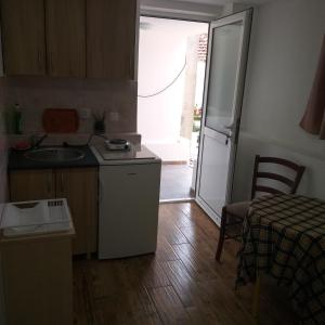 una pequeña cocina con fregadero y nevera. en Petkovic Apartmani 3 en Tivat