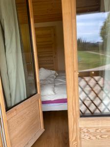 um pequeno quarto com uma cama e uma porta de vidro em Ferme des Moines em Pontarlier