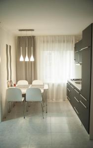 uma cozinha com uma mesa e cadeiras brancas num quarto em Apartment FeLi House em Kiev