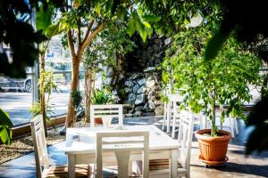une table blanche et des chaises arborées sur la terrasse dans l'établissement Hotel LUKA, à Radom