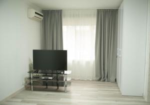 a living room with a flat screen tv in front of a window at Apartment FeLi House in Kyiv