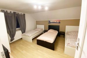 una piccola camera con due letti e una finestra di Work & longstay apartment Ingolstadt a Adelschlag