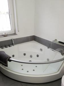 MünstermaifeldにあるSchöne Wohnung Kleiner Onkel auf idyllischem Reiterhof nahe Burg Eltzの窓のある浴室の白い浴槽 +15枚の写真