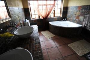 a large bathroom with a tub and a sink at Jocks Cottages in Dullstroom