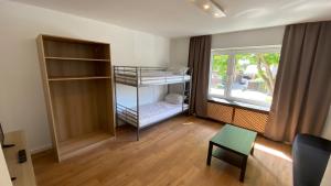 a small room with a bunk bed and a window at BS Living Apartment 1 in Braunschweig