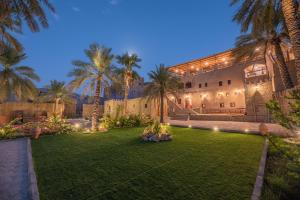 an exterior view of a house with palm trees at Antique Inn in Nizwa