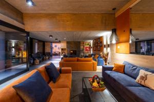 ein Wohnzimmer mit orangefarbenen und blauen Möbeln in der Unterkunft Re Delle Alpi Resort & Spa, 4 Stelle Superior in La Thuile