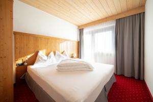 a bedroom with a large white bed with a window at A CASA Bernstein in Sölden