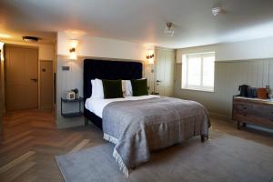 a bedroom with a large bed with green pillows at The Ingham Swan in Stalham