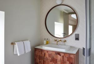 ein Bad mit einem Waschbecken und einem Spiegel in der Unterkunft The Ingham Swan in Stalham