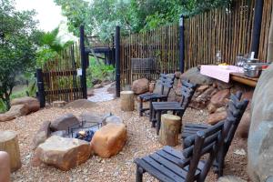 Tatenda Guest House في هازيفيو: حديقة خلفية بها كراسي ومدفأة وسياج