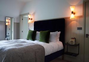 a bedroom with a large bed with green pillows at The Ingham Swan in Stalham