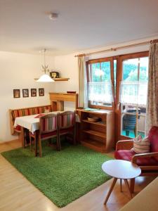 a living room with a table and a green rug at Haus Groder in Rauris