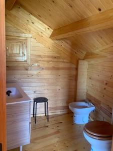 a log cabin bathroom with a toilet and a sink at Casa Rural Rio Chicamo in La Umbría +20 photos