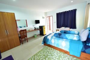 a bedroom with a bed and a desk and a chair at KT Knight Hotel in Surin