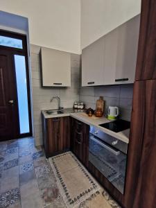 a kitchen with wooden cabinets and a sink and a window at Whiteflower Apartments in Bari