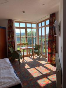 Zimmer mit einem Bett und einem Tisch mit Stühlen in der Unterkunft Ferienappartement mit Panoramablick in Rötz